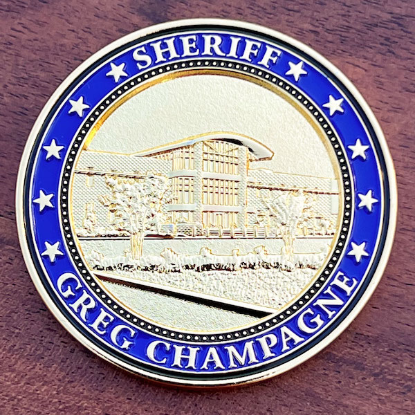 Polished gold challenge coin belonging to St. Charles Parish, Louisiana Sheriff Greg Champagne